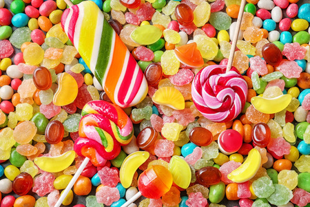 与柳叶刀笔和嘉的颜色背景在各种各样的颜色的棒棒糖一套一组甜糖果