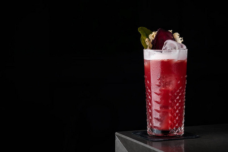 红色鸡尾酒与泡沫, 甜菜和薄荷在一个寒冷的玻璃在酒吧在黑色的背景。滴, 露水和冰, 红甜菜