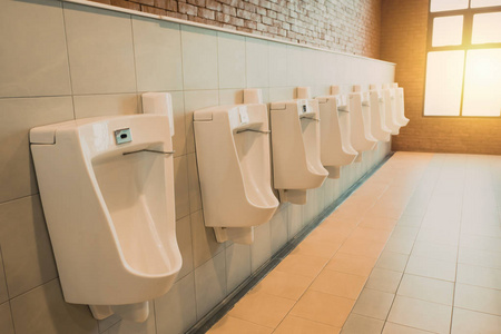 上厕所关闭行户外小便池男子公共厕所,特写了白色的小便池在男厕所里