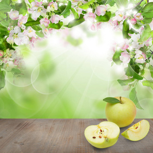 绿叶春花苹果果和灰色空木板上抽象软聚焦散景光背景