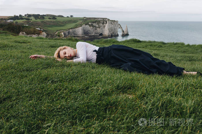 美丽的女孩躺在草地上的悬崖上鲁昂诺曼底法国