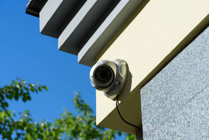 在日光下建筑物立面上的安全摄像头特写视图
