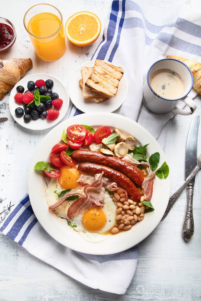 传统的全英式早餐配煎蛋,香肠,豆类,蘑菇和熏肉