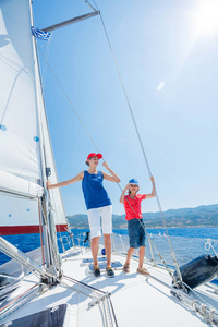 男孩和他的姐姐在船上的游艇航行在夏天巡航。冒险旅行，家庭度假游艇与孩子