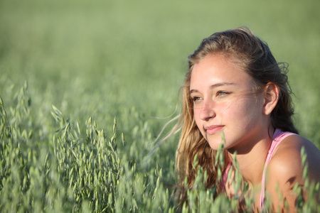 美丽的十几岁的女孩在燕麦草甸的肖像