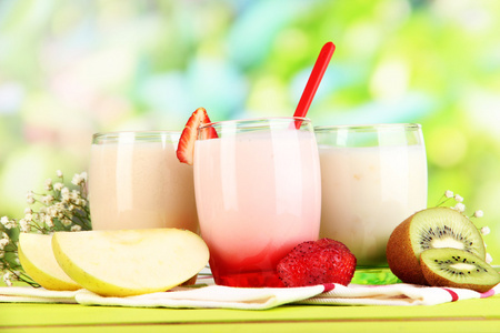 美味酸奶与水果的自然背景上的木桌上的眼镜