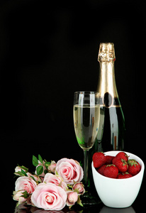浪漫静物与香槟 草莓和粉红色的玫瑰，孤立在黑色