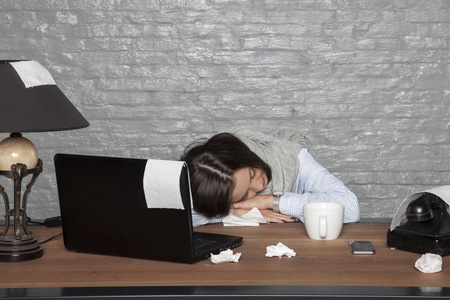 生病的商业妇女在办公桌上睡着了疲惫