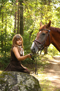 美丽的姑娘和褐色的马画像在神秘的森林