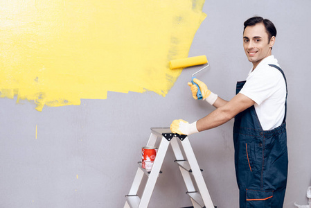 阿拉伯人的外貌是一个画家的作品。一个人在粉刷墙壁。他穿着特别的制服