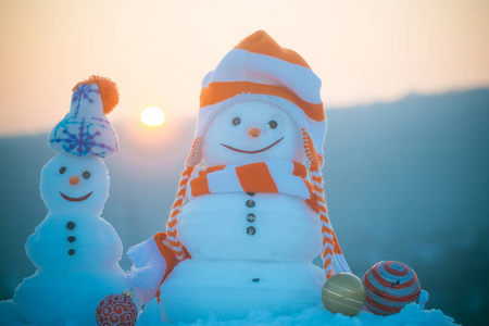 日落天空中的两个雪雕塑与笑脸图片