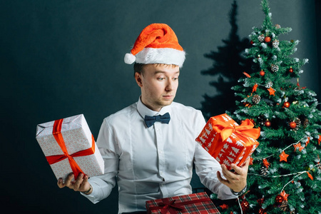 拿着 giftbox 的人英俊的男性与礼物箱子在手在圣诞节树