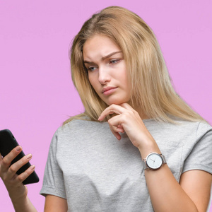 年轻的白种人妇女发送消息使用智能手机在孤立的背景严重的面孔思考问题, 非常混淆的想法