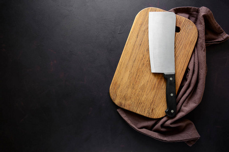 长方形切割板, 配有烹饪用的配料和深色木质背景的刀。顶部视图。复制空间