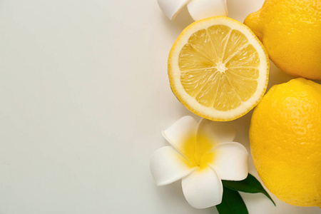成熟多汁的柠檬和异国情调的花在白色背景, 顶部视图