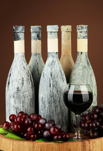 组成与旧瓶的红酒和酒杯在老酒窖，暗棕色背景上
