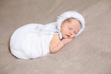 睡在轻轻地蓝色针织帽子初生女婴