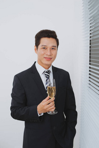 微笑着的年轻 businesman, 站在香槟杯