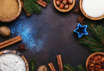 圣诞节或新年组成与成分烘焙或与黄金雪花, 圣诞球, 绿色杉木树枝, 松树锥, 在蓝色棕色背景, 框架, 顶部视图