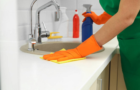 妇女在保护手套清洁厨房水槽与抹布, 特写镜头