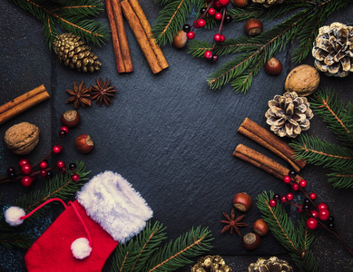 圣诞节或新年黑暗背景, 框架, 模板, 节日装饰品, 冬季香料和圣诞装饰品, 坚果和冷杉树枝, 顶部视图