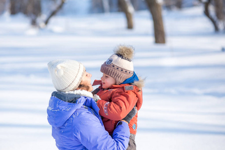 妇女与一个小孩子在公园为冬天散步