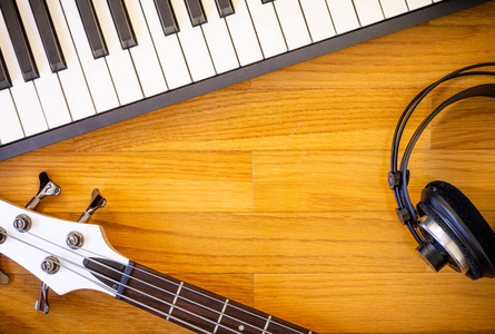 键一对一个木制背景与一套乐器组成的一个键盘, 低音吉他和一对耳机