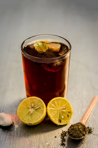受欢迎的夏季饮料卡拉 Khatta Sharbat 与装饰成分切片柠檬, 盐和黑胡椒在木表面