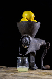 旧铸铁果汁机在木制餐桌上。柠檬瑞