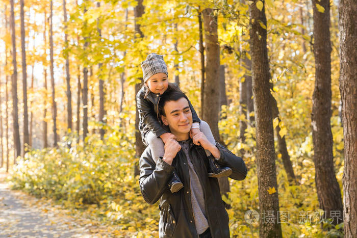 父亲, 孩子和家庭概念-爸爸在秋季公园里抱着他的女儿