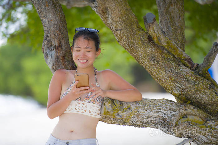 甜美漂亮的亚洲女人使用手机发送互联网社交媒体文本微笑快乐享受假期