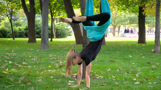 在公园里从事空中瑜伽的女孩