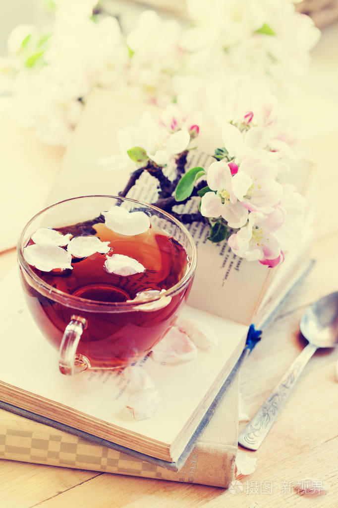 新鲜茶杯的特写镜头视图与花瓣在书