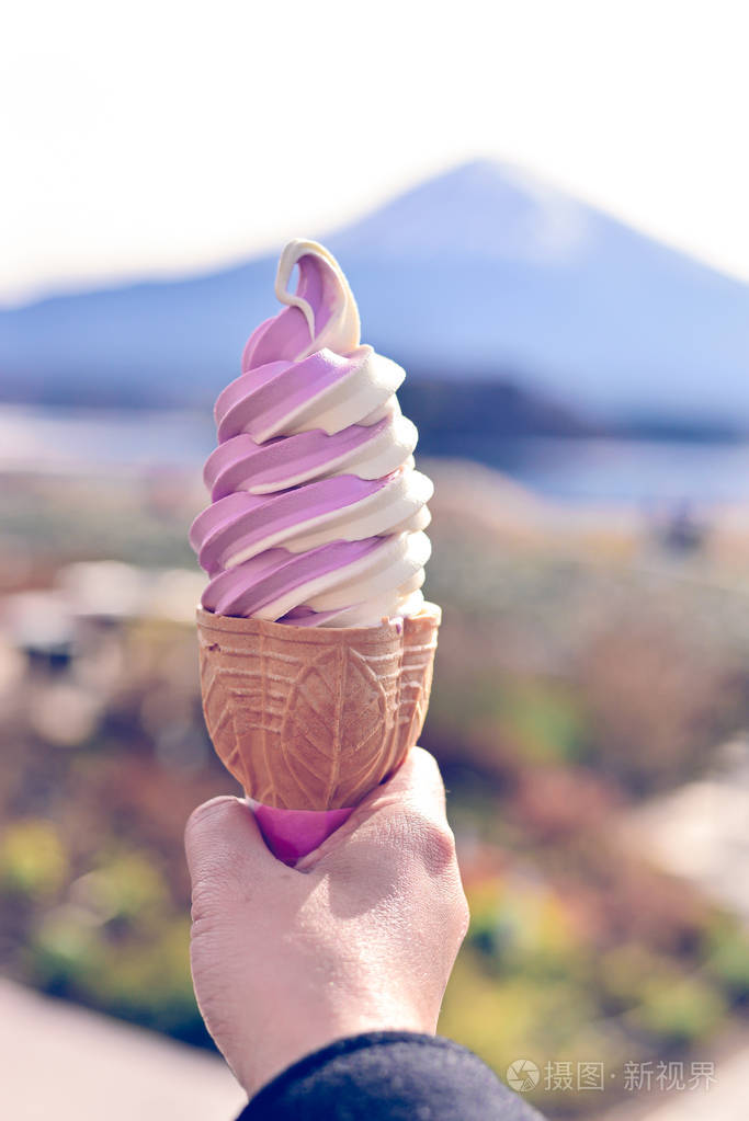 妇女手捧着两个音冰淇淋在一个锥富士山背景