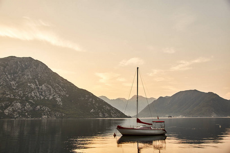 日落在 Kotor 湾。Kotor 湾一艘孤独的游艇。黑山