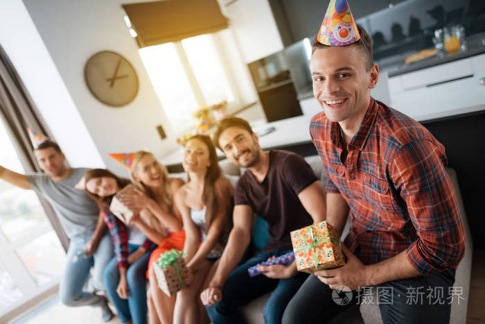 参加生日聚会的人拍一张合影他们坐在沙发上
