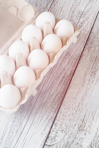 纸板鸡蛋架与鸡蛋在白色的木桌上, 色调