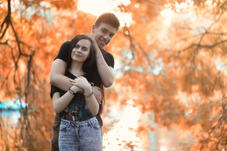 在秋天公园散步的年轻夫妇