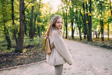 微笑的小女孩站立在森林里漫步在秋天天