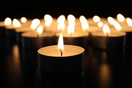 在黑暗中的桌子上燃烧蜡烛, 特写。葬礼标志
