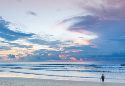 一个人站在海上冲浪在他的手上的海岸
