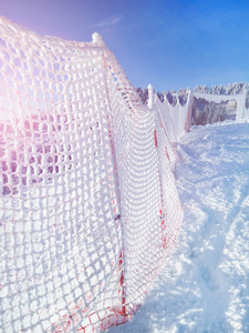 滑雪斜坡的细胞。白雪覆盖着山顶上的红篱笆