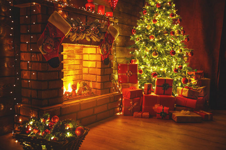 室内圣诞节。魔法发光的树, 黑暗中的壁炉礼物