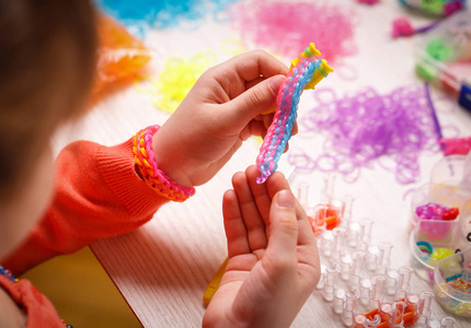 彩色的橡皮圈纺织配件在一个女孩的手中