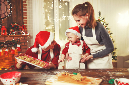 家庭母亲爸爸和婴孩烘烤圣诞节曲奇饼