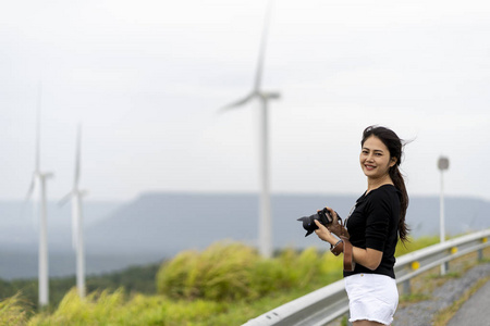 亚洲妇女非常高兴地拍摄风车和草原