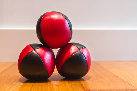 三红色和黑色杂耍球在木表面