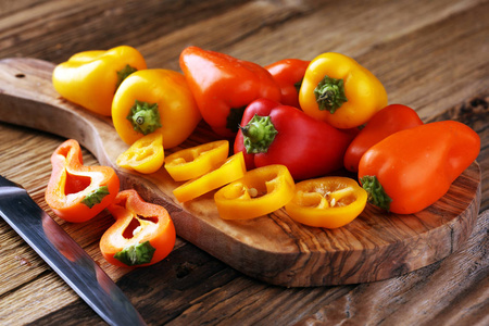新鲜的红色, 黄色和橙色的甜椒在木质背景。生蔬菜