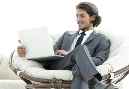 现代的商人，在时尚舒适的椅子上坐着一台手提电脑