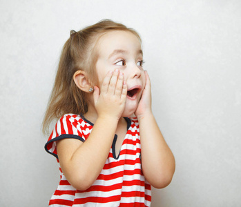 惊讶的小女孩张开嘴和双手脸颊照片